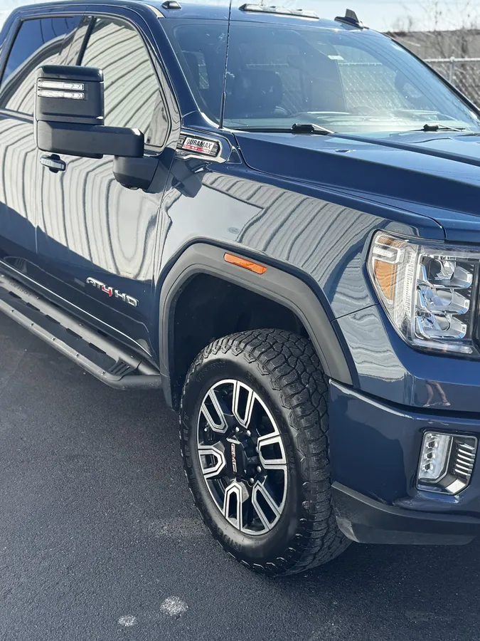 Reflection in the paint of a dark blue GMC Sierra AT4 HD after paint correction